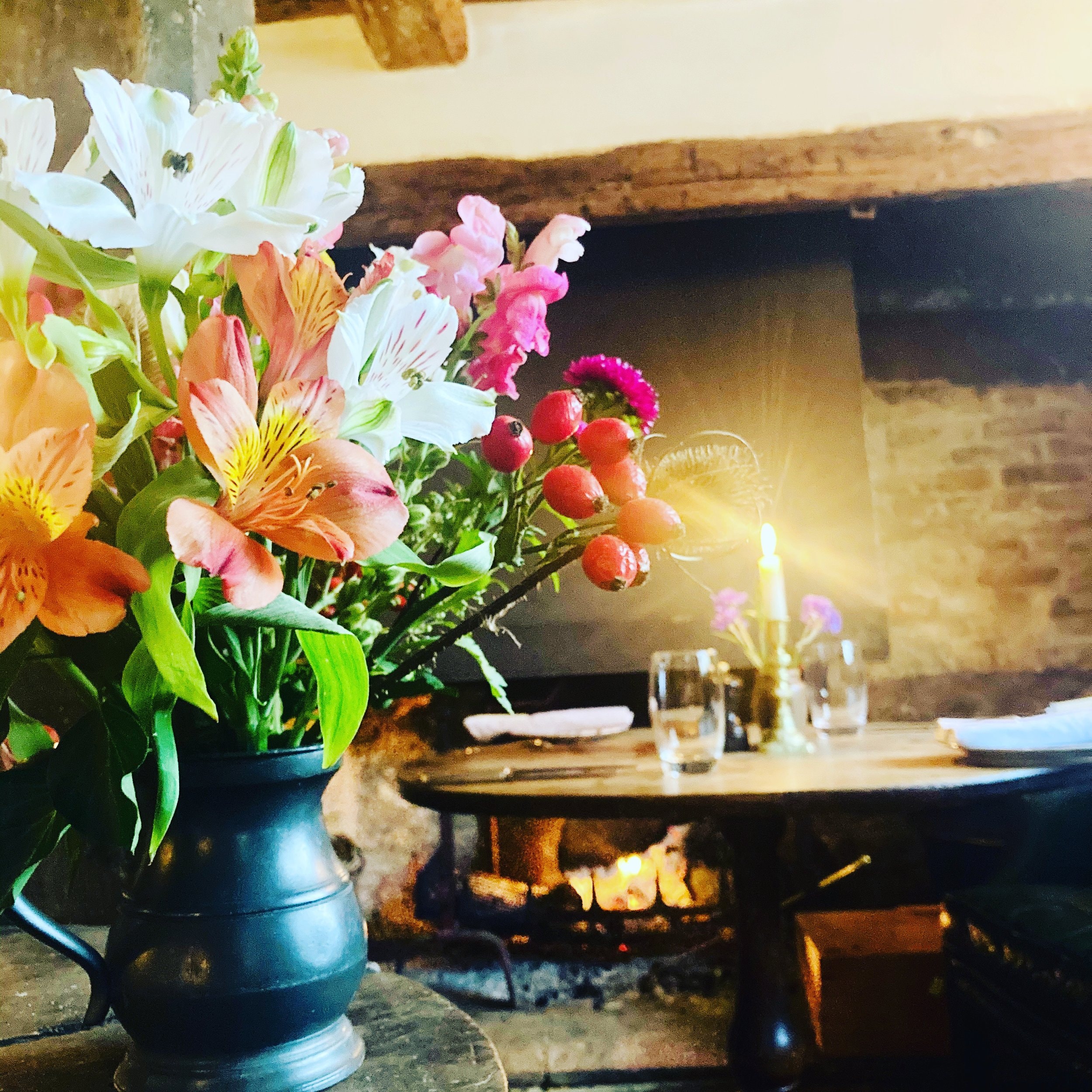 Interior with flowers and inglenook fireplace