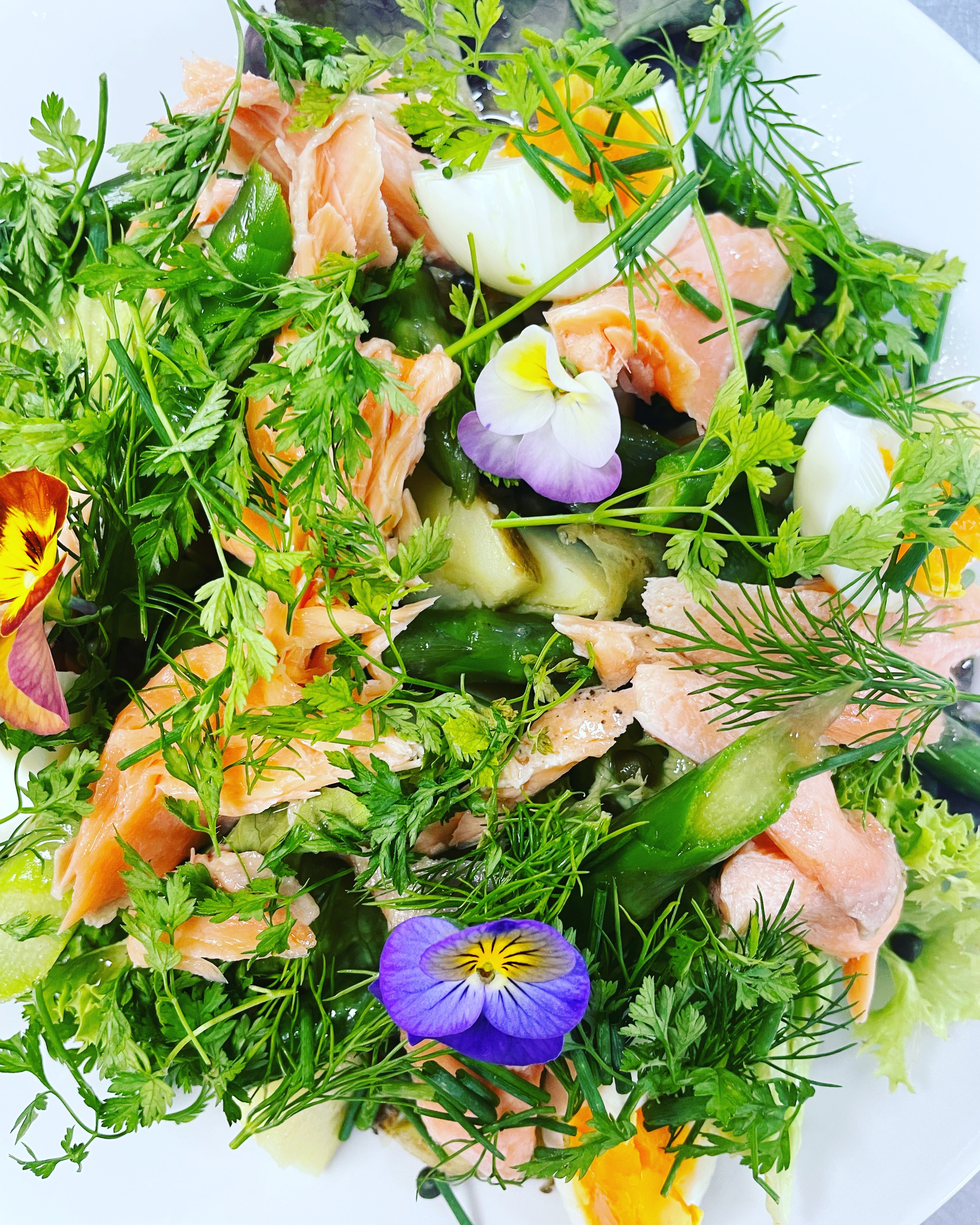 Smoked trout salad with edible flowers and herbs